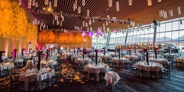 A decorated ballroom with many dining tables set up